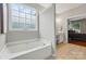 Relaxing bathroom with a soaking tub and a glimpse into the bedroom at 14402 Asheton Creek Dr, Charlotte, NC 28273