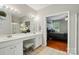 Bright bathroom featuring double vanity, tiled floors and a glimpse into a bedroom at 14402 Asheton Creek Dr, Charlotte, NC 28273