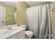 Well-lit bathroom with a neutral color palette, a modern shower curtain, and ample vanity space at 14402 Asheton Creek Dr, Charlotte, NC 28273