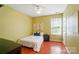 Bright bedroom with yellow walls, hardwood floors, ceiling fan and a single bed at 14402 Asheton Creek Dr, Charlotte, NC 28273
