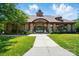 Well-manicured clubhouse entrance with stone accents, lush landscaping, and inviting pathway at 14402 Asheton Creek Dr, Charlotte, NC 28273