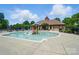 View of community pool with wading area, slide, seating, and clubhouse, perfect for Gathering fun at 14402 Asheton Creek Dr, Charlotte, NC 28273