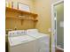 Functional laundry room equipped with a washer, dryer, and shelving for storage and organization at 14402 Asheton Creek Dr, Charlotte, NC 28273