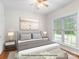 This staged main level bedroom includes a bed, windows and a ceiling fan at 14426 Harvington Dr, Huntersville, NC 28078