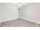 This neutral bedroom features large windows with green views and neutral carpet at 14426 Harvington Dr, Huntersville, NC 28078