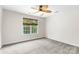 Neutral bedroom with large window with green leafy views and ceiling fan at 14426 Harvington Dr, Huntersville, NC 28078