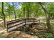 Charming wooden bridge over a small creek in a wooded community area at 14426 Harvington Dr, Huntersville, NC 28078
