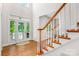 Bright foyer featuring hardwood floors, staircase, and a door leading to the outside at 14426 Harvington Dr, Huntersville, NC 28078