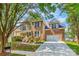 This two-story brick home features a well-manicured front yard, attached garage, and a welcoming entrance at 14426 Harvington Dr, Huntersville, NC 28078