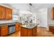 Well-lit kitchen with granite countertops, island, stainless steel dishwasher, and wooden cabinets at 14426 Harvington Dr, Huntersville, NC 28078