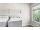 Laundry room with washer, dryer, storage shelf and window for natural light at 14426 Harvington Dr, Huntersville, NC 28078