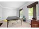 Bonus room features a ping pong table, natural light, and neutral carpeting at 16028 Hallaton Dr, Huntersville, NC 28078