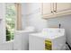 Laundry room with washer, dryer, window for natural light, and storage shelves at 16028 Hallaton Dr, Huntersville, NC 28078