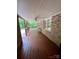 View of covered porch with wooden floors, brick siding, and a wicker chair at 1623 Arbor Way, Albemarle, NC 28001