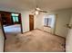 Bright bedroom with carpet and a ceiling fan; adjacent to a room with wood paneling at 1623 Arbor Way, Albemarle, NC 28001
