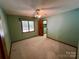 Bedroom featuring green walls, carpet, ceiling fan, and an open closet for storage at 1623 Arbor Way, Albemarle, NC 28001