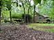 View of a home with lush, mature landscaping, trees, and brick facade at 1623 Arbor Way, Albemarle, NC 28001