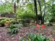 Landscaped front yard with blooming flowers, mature trees, and an American flag at 1623 Arbor Way, Albemarle, NC 28001