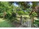 Beautiful backyard with lush greenery, mature trees, a wooden gate, and well-maintained landscaping at 1687 Windy Hill Ln, Great Falls, SC 29055
