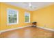Bright bedroom with hardwood floors, a ceiling fan and two windows at 1687 Windy Hill Ln, Great Falls, SC 29055