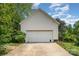 Spacious two-car garage with a white door and ample parking space in a tree-lined area at 1687 Windy Hill Ln, Great Falls, SC 29055