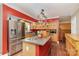 Bright kitchen features stainless steel appliances, a large island and decorative cabinets with red accent walls at 1687 Windy Hill Ln, Great Falls, SC 29055