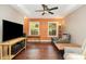 Comfortable living room with hardwood floors, bright orange accent wall, and modern ceiling fan at 1687 Windy Hill Ln, Great Falls, SC 29055