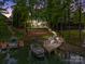 Scenic aerial view of a lakefront property featuring a private dock, boat, pool, and elegant home nestled in lush greenery at 19614 Meta Rd, Cornelius, NC 28031