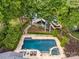 Stunning aerial view of the backyard featuring a gorgeous pool, dock, boat, landscaping, and waterfront at 19614 Meta Rd, Cornelius, NC 28031