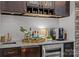 Elegant bar area with a wine fridge, custom cabinetry, granite countertops, and a stylish backsplash at 19614 Meta Rd, Cornelius, NC 28031