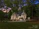 Charming stone and siding home with a well-manicured lawn and a playful shed nestled in a lush, tree-filled landscape at 19614 Meta Rd, Cornelius, NC 28031
