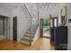 Bright foyer boasts hardwood floors, an elegant staircase with iron railings, and a view of the front lawn at 19614 Meta Rd, Cornelius, NC 28031