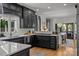Modern kitchen boasts stainless steel appliances, dark cabinetry, and an open layout to the dining area at 19614 Meta Rd, Cornelius, NC 28031
