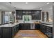 Stunning kitchen featuring dark cabinets, white countertops, stainless steel appliances, and hardwood floors at 19614 Meta Rd, Cornelius, NC 28031