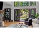 Bright living room with high windows, hardwood floors, a comfortable armchair, and a view of the backyard at 19614 Meta Rd, Cornelius, NC 28031