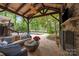 Inviting outdoor living area with a cozy fireplace, comfortable seating, and view of the pool at 19614 Meta Rd, Cornelius, NC 28031