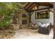 Charming outdoor area with a stone fireplace, plush seating, and serene backyard views, perfect for relaxation at 19614 Meta Rd, Cornelius, NC 28031