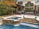 Inviting outdoor pool and spa with stone accents, perfect for relaxation and entertaining with a covered outdoor space at 19614 Meta Rd, Cornelius, NC 28031