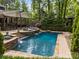 Beautiful pool with waterfall features and outdoor lounging space surrounded by lush greenery creating a private oasis at 19614 Meta Rd, Cornelius, NC 28031