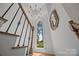 Elegant staircase featuring a decorative chandelier, hardwood steps, and a large arched window at 19614 Meta Rd, Cornelius, NC 28031