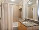 Well-lit bathroom features a shower/tub combo with decorative tile surround, granite counter vanity at 210 N Church St # 2613, Charlotte, NC 28202