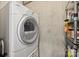 White front load washer and dryer set with laundry storage on metal racks at 210 N Church St # 2613, Charlotte, NC 28202