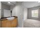 There is a vessel sink on a wood vanity and a doorway leading into a bedroom with a large window at 2125 Southend Dr # 448, Charlotte, NC 28203