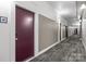 Long hallway with neutral tones and a carpeted floor leading to other units with sconce lighting along the walls at 2125 Southend Dr # 448, Charlotte, NC 28203