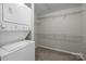 Efficient laundry area with stacked washer and dryer, plus shelving providing storage solutions at 2125 Southend Dr # 448, Charlotte, NC 28203