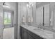 Bathroom with double sinks, gray cabinets, marble countertops, and chrome fixtures at 2925 Westfield Rd, Charlotte, NC 28209