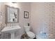 Stylish powder room features a pedestal sink, decorative wallpaper, and modern fixtures at 2925 Westfield Rd, Charlotte, NC 28209
