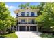 Charming two-story home featuring a brick facade, a black 2-car garage, and an inviting second-story porch at 2925 Westfield Rd, Charlotte, NC 28209