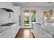 Modern kitchen with white cabinets, stainless steel appliances, and access to the outdoor balcony at 2925 Westfield Rd, Charlotte, NC 28209