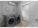 Well-lit laundry room featuring gray washer and dryer, mini-split AC, light gray walls, and white trim at 2925 Westfield Rd, Charlotte, NC 28209